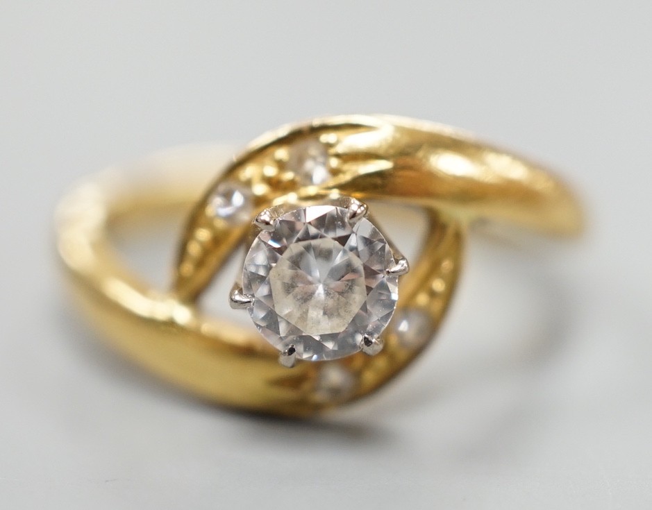 A continental yellow metal and single stone diamond set ring, with diamond set crossover shoulders, size I, gross weight 3.2 grams.